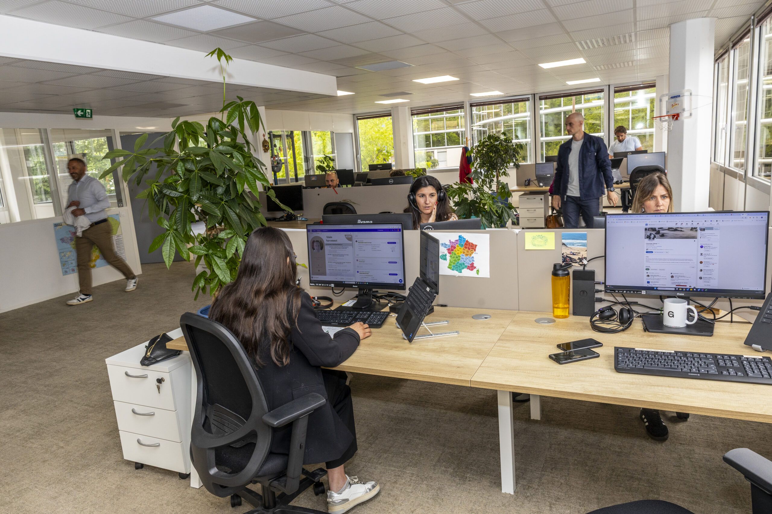 Open space collaboratif dans un cabinet de conseil RH à Toulouse, avec des collaborateurs au travail sur leurs ordinateurs dans un environnement lumineux et végétalisé