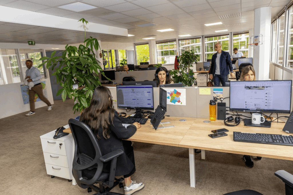 Open space collaboratif dans un cabinet de conseil RH à Toulouse, avec des collaborateurs au travail sur leurs ordinateurs dans un environnement lumineux et végétalisé.