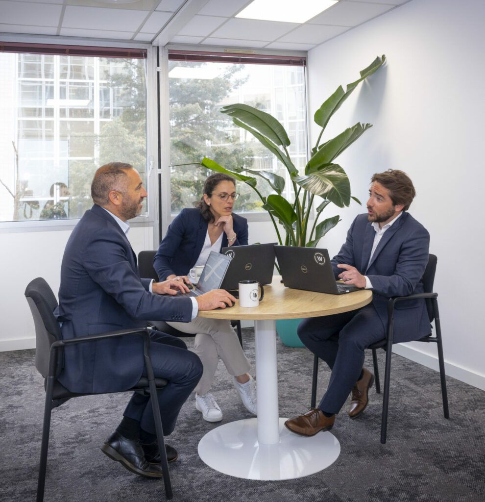 Réunion entre consultants RH dans une salle de travail moderne à Toulouse, au sein d’un cabinet de conseil en recrutement